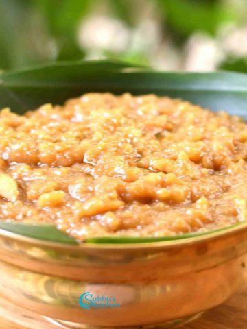 A traditional bowl of Sakkarai Pongal garnished with ghee-roasted cashews and raisins, served as a South Indian festive sweet dish.