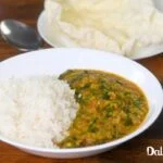 A bowl of creamy Dal Palak, made with lentils and spinach, garnished with tempering of mustard seeds, cumin, and red chilies, served hot with rice or roti.