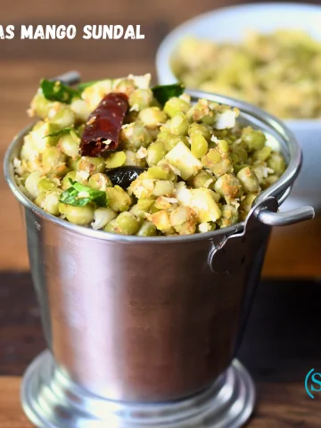 A bowl of Peas Mango Sundal (Pattani Sundal) garnished with grated coconut and raw mango, a traditional South Indian festival snack.